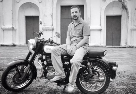 <h3>Voyage initiatique au Rajasthan</h3>

Premiers tours de roues dans les années 80 sur une Suzuki 125 puis c’est au guidon d’une BMWR100 qu’il fera de beaux road-trips en Turquie et en Grèce. Père de famille, pris dans le tourbillon de la vie, il fait une « pause moto ». Après une dizaine d’années de silence motorisé, Serge, son ami d’enfance, vient lui proposer un <a href="https://www.vintagerides.com/voyage-moto/inde-du-nord-rajasthan/">voyage moto en Inde du Nord</a>. En 2012, les deux potes se jettent dans le grand bain : le Rajasthan, en formule liberté, sans guide, ni réservation d’hôtels ou assistance mécanique. L’équipe Vintage Rides rencontre les drôles d’oiseaux suisses au garage de Delhi pour leur donner les bécanes, quelques pièces détachées, un GPS et de précieux conseils en mécanique enfieldienne. 